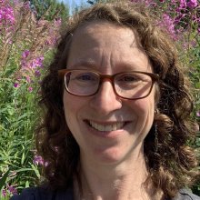 Headshot of Leah Berman in front of blooming fireweed